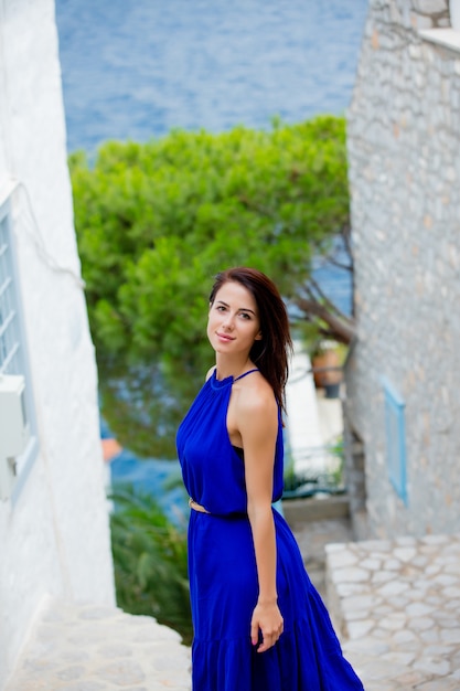 Photo photo d'une belle jeune femme debout dans l'escalier près des maisons en grèce