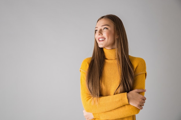 Photo d'une belle jeune femme heureuse isolée sur un mur gris.