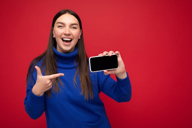 Photo de belle jeune femme souriante à la recherche de vêtements élégants décontractés debout