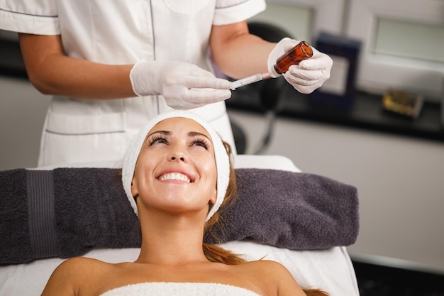 Photo d'une belle jeune femme sur un traitement de micro-aiguilletage du visage au salon de beauté.