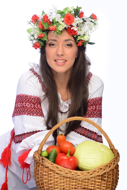 Photo d'une belle et mignonne femme en costume ukrainien avec panier de légumes