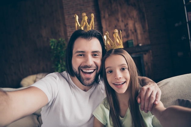 Photo de belle petite fille adorable et beau jeune papa assis sur un canapé confortable