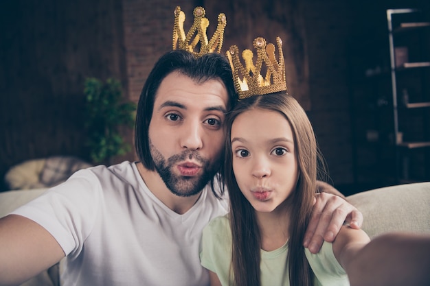 Photo de belle petite fille adorable et beau jeune papa assis sur un canapé confortable