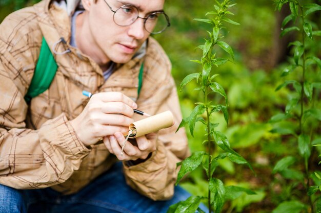 Photo d'un biologiste masculin dans des verres avec un bloc-notes