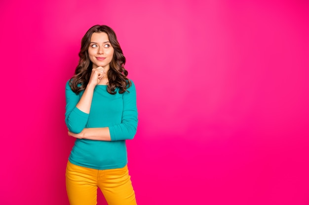 Photo de bonne humeur positive jolie jolie petite amie ondulée bouclés portant un pantalon jaune pantalon à la recherche dans un espace vide isolé fond de couleur fuchsia vif