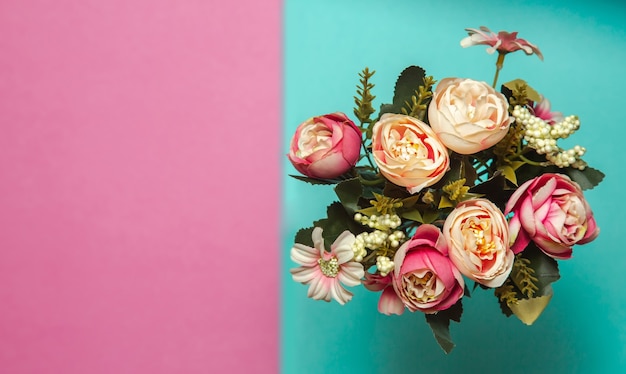 Photo d'un bouquet de fleurs roses sur un fond texturé rose et bleu avec des motifs