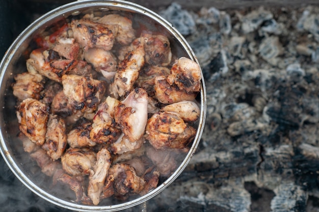 Photo d'une brochette de poulet dans une grande casserole sont dans un brasier éteint en hiver