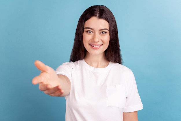 Photo d'une charmante jeune fille joyeuse de bonne humeur donner un bras demander une invitation isolée sur fond de couleur bleu.