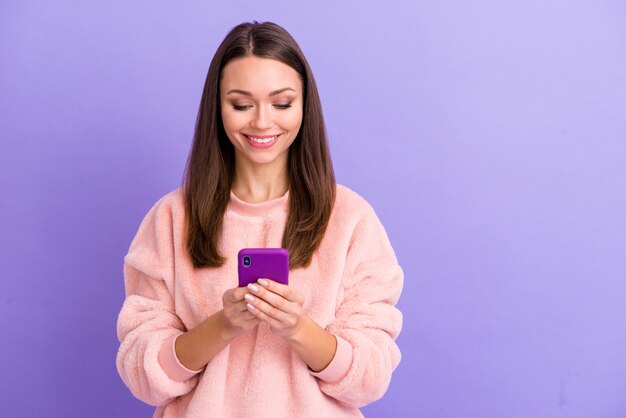 Photo de cheerful blogger lady holding phone look screen sur mur violet