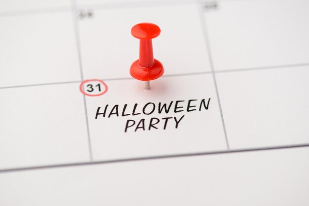 Photo ci-dessus de la date de l'étiquette 31 octobre avec inscription fête d'halloween avec épingle rouge isolée sur le fond du calendrier
