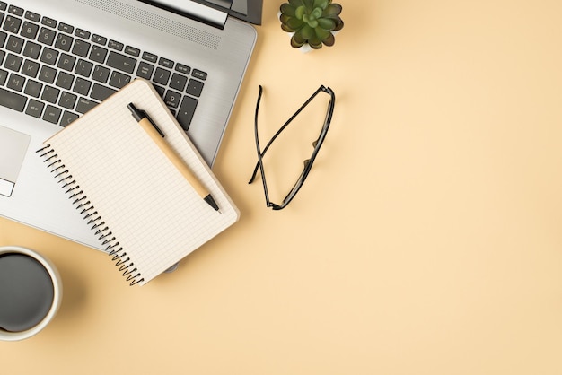 Photo ci-dessus d'une plante de lunettes de stylo pour ordinateur portable et d'une tasse de café isolée sur le fond beige avec fond