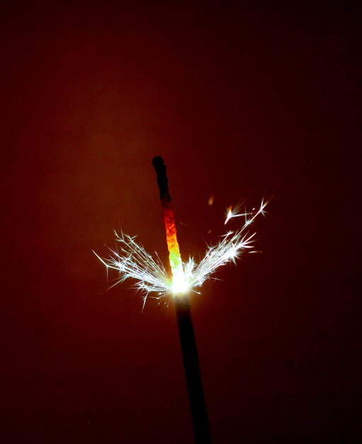 Photo photo d'un cierge magique de fête sur fond marron foncé