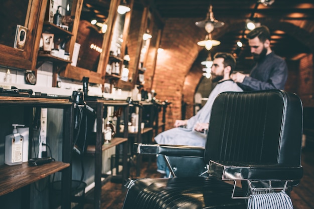 Photo une photo d'un coiffeur debout sur le dos de son client et mettant une couverture sur les épaules de son client.