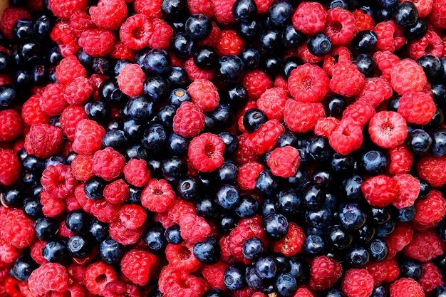 Une photo complète de bleuets et de framboises