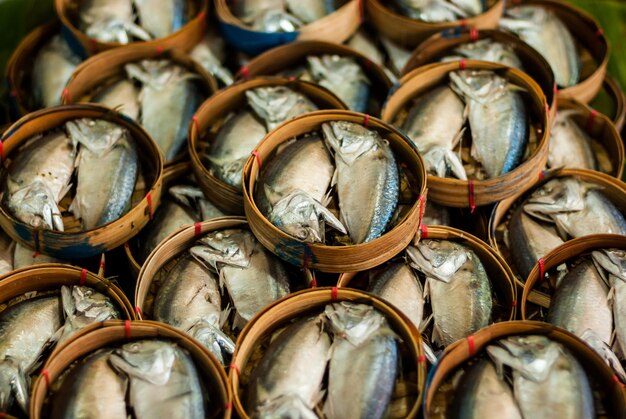 Une photo complète de poissons dans des paniers au marché à vendre