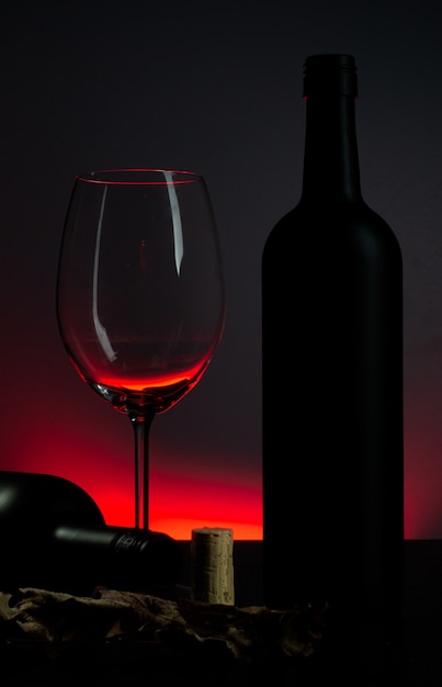 Photo conceptuelle de bouteille de vin et de verre sur fond rouge.