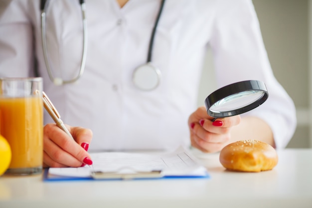 Photo conceptuelle d'une nutritionniste femme avec des fruits sur le bureau