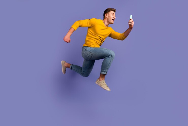 Photo côté profil pleine grandeur d'un jeune homme sauter courir utiliser le téléchargement du bouton mobile isolé sur fond de couleur violette