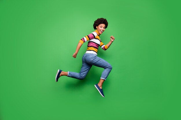 Photo de côté de profil pleine taille d'une fille afro-américaine joyeuse positive courir après l'automne noir vendredi bonne affaire porter des jeans en jean