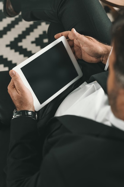 Une photo coupée d'un homme d'affaires utilisant une tablette.