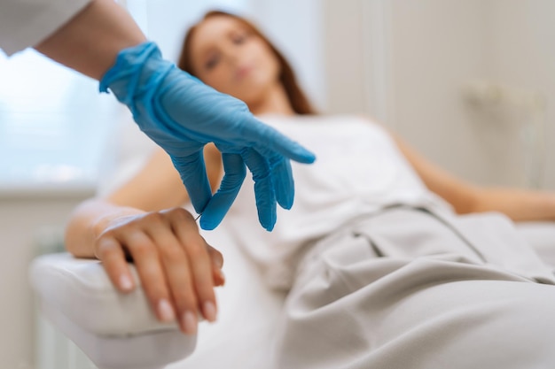 Une photo coupée d'un maître d'acupuncture méconnaissable retirant des aiguilles de guérison du bras du patient après