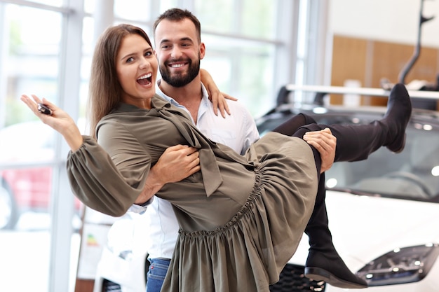 Photo d'un couple adulte choisissant une nouvelle voiture dans une salle d'exposition