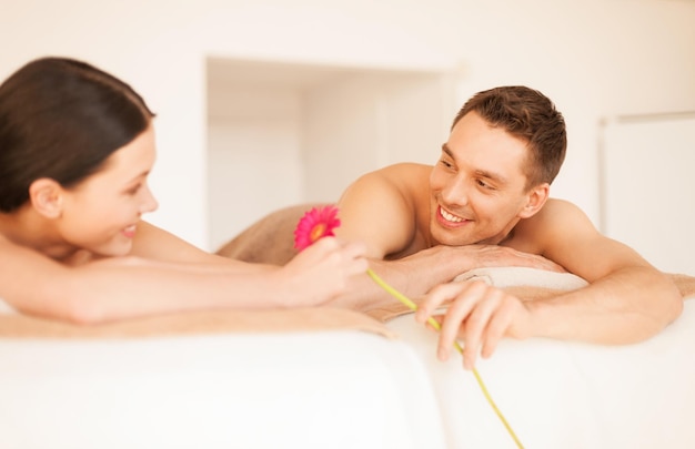 photo de couple dans un salon spa allongé sur les tables de massage