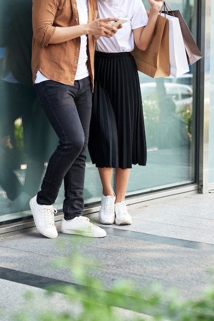 Une photo d'un couple faisant du shopping avec un smartphone dans la ville