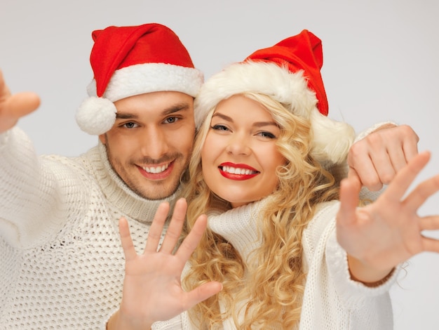 photo de couple de famille en chandails et chapeaux de père Noël