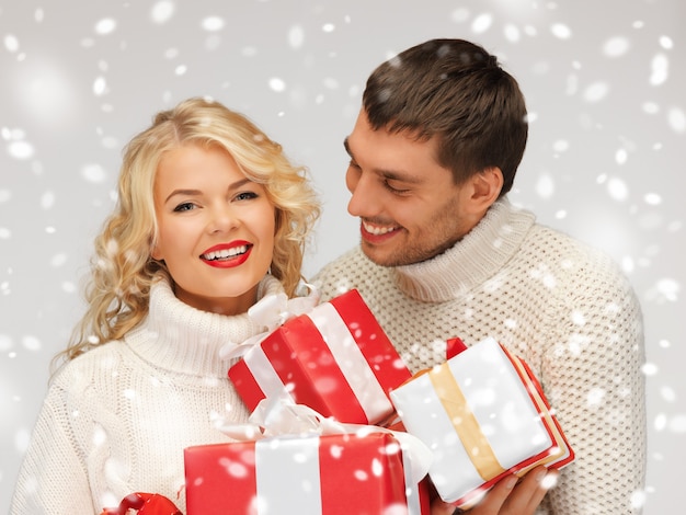 photo d'un couple de famille dans un chandail avec des coffrets cadeaux