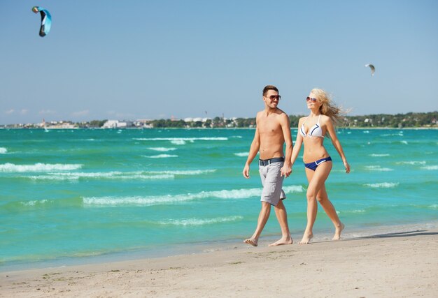 photo d'un couple heureux marchant sur la plage.