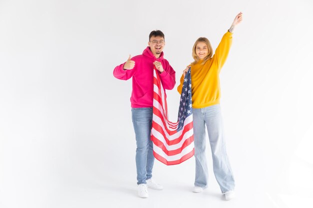 Photo d'un couple multiethnique attrayant homme et femme enveloppés dans un drapeau américain