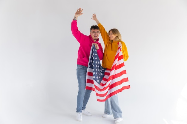 Photo d'un couple multiethnique attrayant homme et femme enveloppés dans un drapeau américain