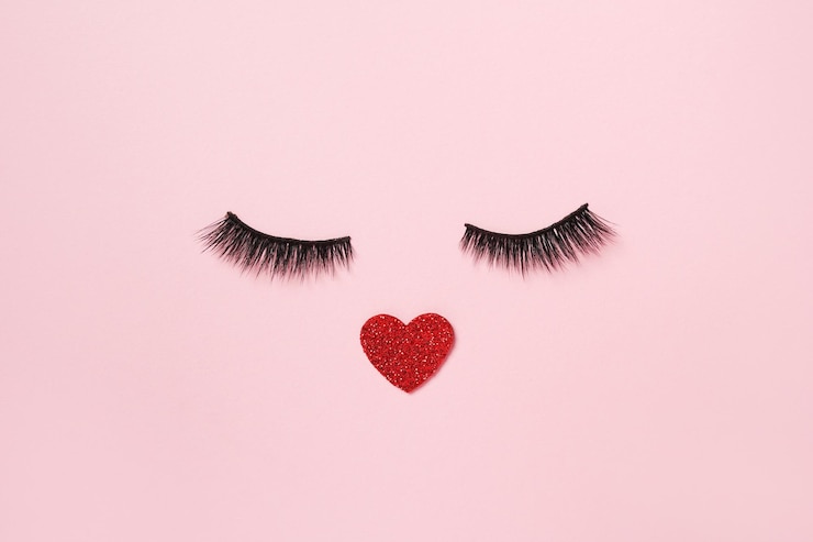 Photo photo créative d'un cœur avec de faux cils sur fond rose