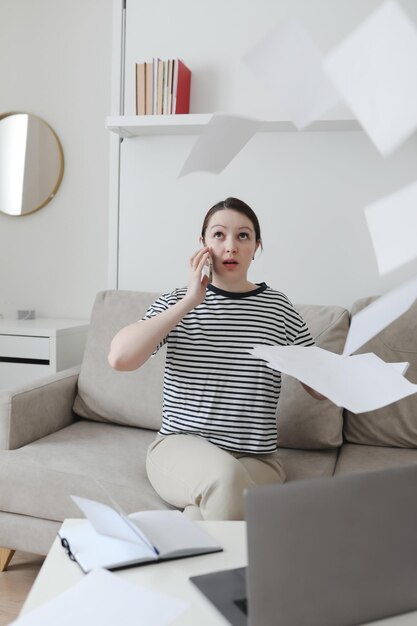 Photo créative d'une femme d'affaires occupée travaillant avec des documents sur le lieu de travail dans un bureau moderne