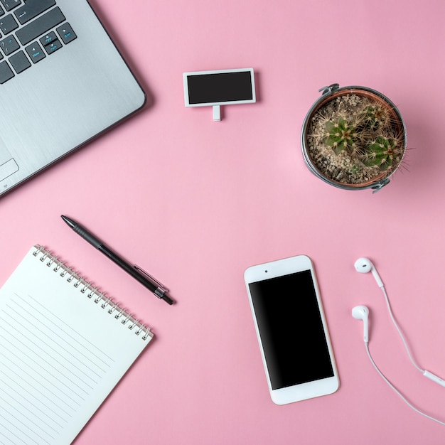 Photo créative à plat du bureau de l'espace de travail avec cactus et ordinateur portable pour smartphone et ordinateur portable