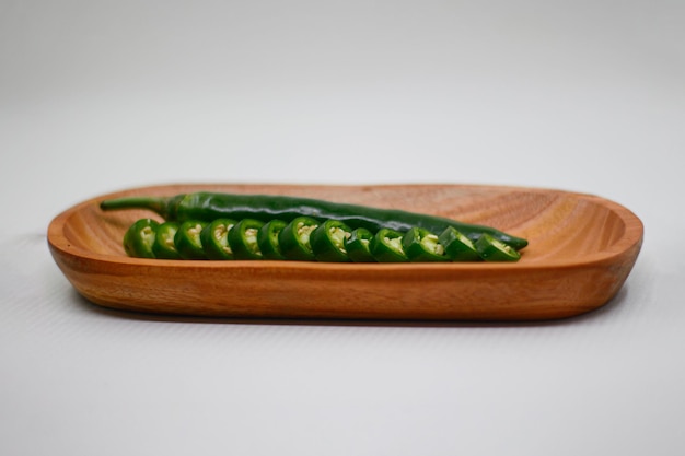 Photo crue et coupe gros piment vert sur un plateau en bois