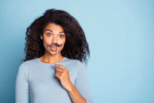 Photo de cute nice sweet jolie petite amie avec des lèvres boudé tenant de fausses moustaches sur bâton isolé fond de couleur pastel