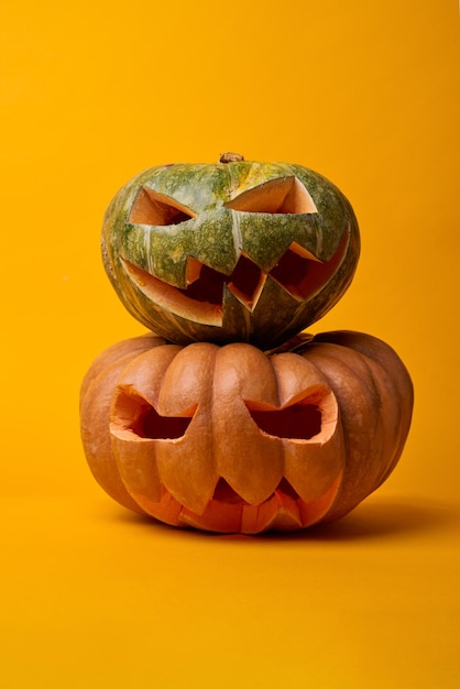 Photo de deux citrouilles d'halloween sur fond orange vide