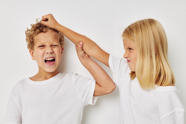 Photo de deux enfants en t-shirts blancs debout à côté de l'enfance inchangée