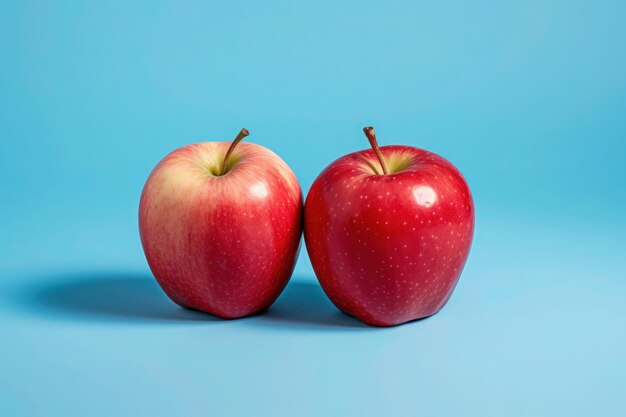 une photo de deux pommes sur fond bleu