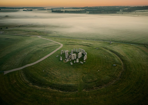 Photo de drone du monument préhistorique de Stonehenge dans un paysage verdoyant au crépuscule dans le Wiltshire, en Angleterre