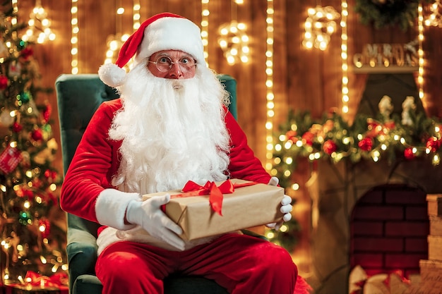 Photo du joyeux père Noël en lunettes de vue en regardant la caméra