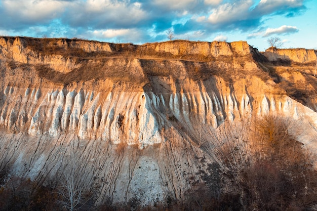 Photo du soir d'une falaise de craie. Carrière de craie, haute paroi presque verticale de craie