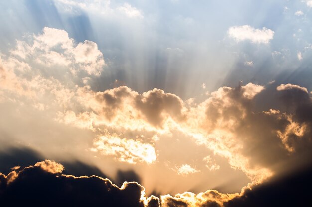 Une photo du soleil qui brille à travers les nuages