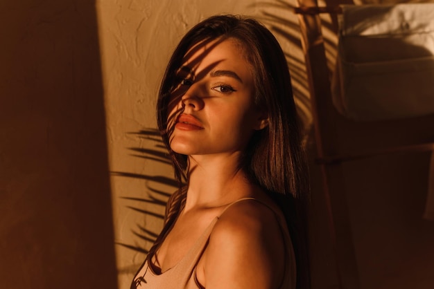 Photo photo élégante d'un modèle féminin à l'ombre d'une feuille de palmier