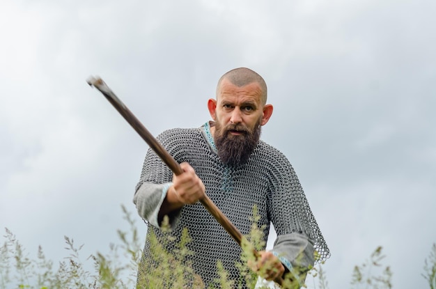 Photo une photo émouvante d'un viking médiéval dans une cotte de mailles en métal balançant une hache
