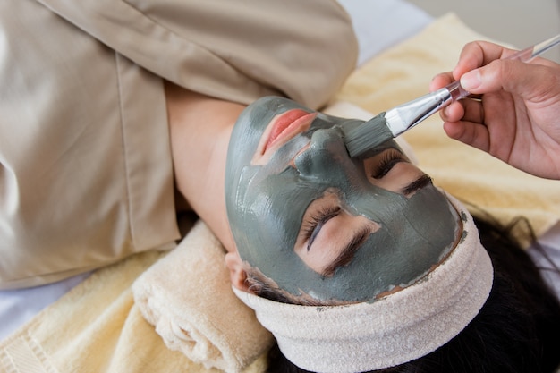 Photo d'une esthéticienne faisant un masque facial