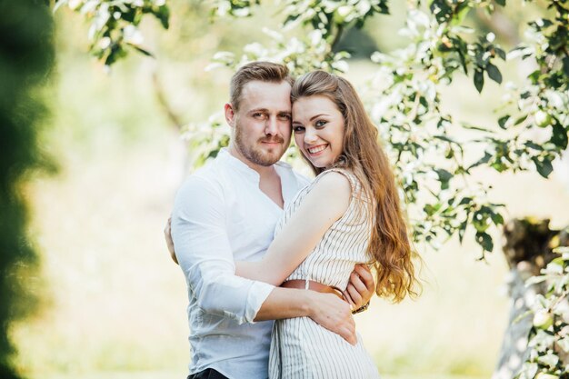 Photo d'été d'un beau jeune couple dans le jardin