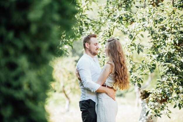 Photo d'été d'un beau jeune couple dans le jardin